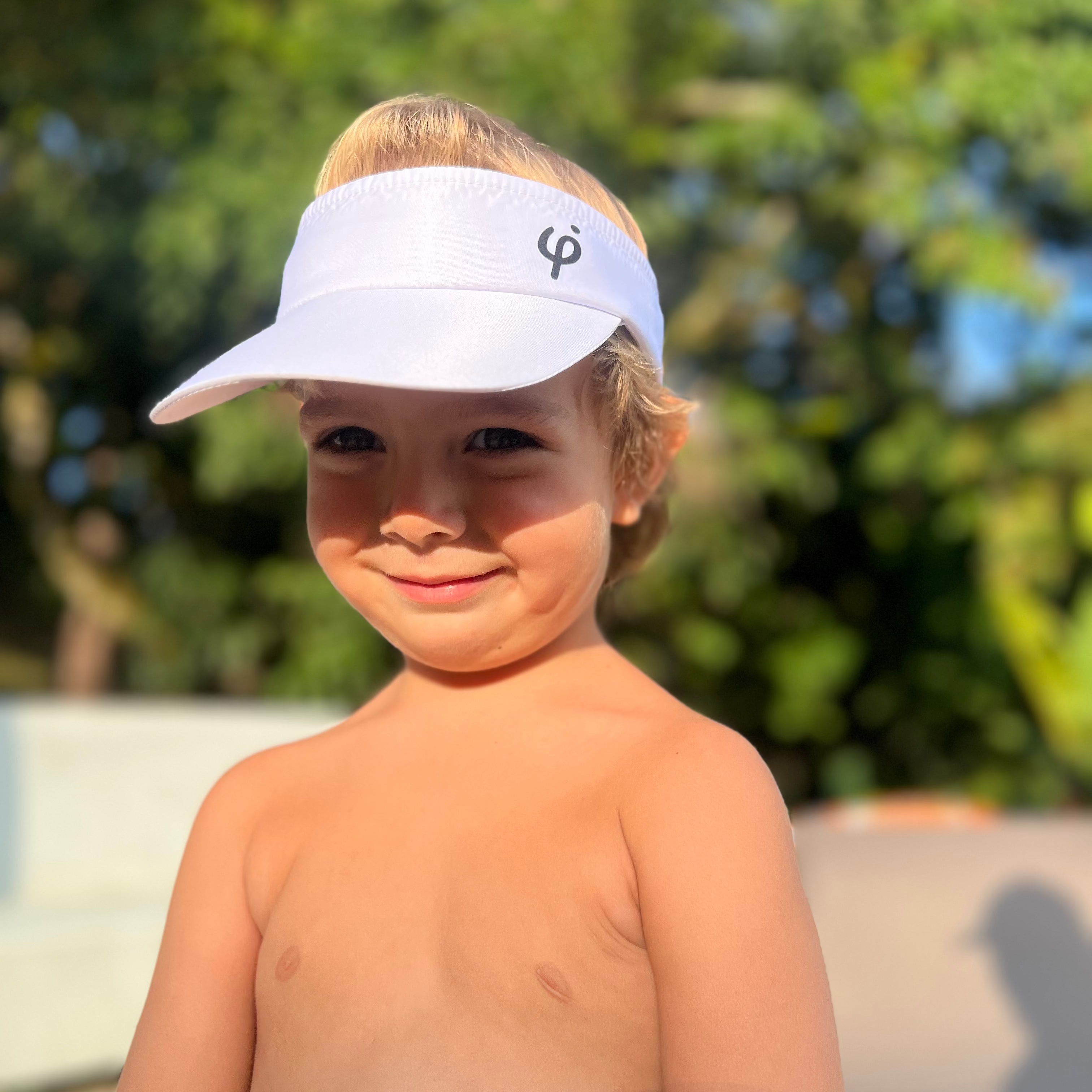 Primer plano de niño usando visera blanca Frouros, destacando el ajuste perfecto y la protección en el rostro para actividades recreativas.